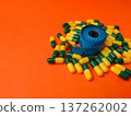 Collection of capsules and a measuring tape on a orange background. 137262002