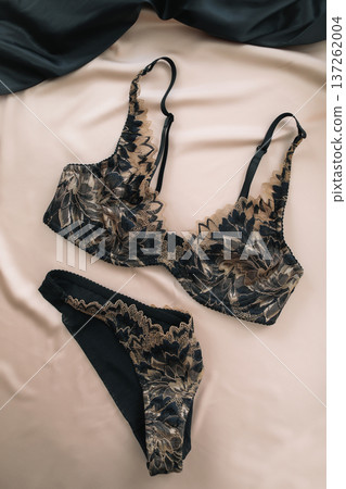 Woman's lingerie on the bed sheets. Lace sexy female underwear. Beauty, fashion blogger concept. Female bra, panties, erotic clothes. Lingerie advertising Woman's lingerie on the bed sheets. Lace sexy female underwear. Beauty, fashion blogger concept. Female bra, panties, erotic clothes. Lingerie advertising 137262004