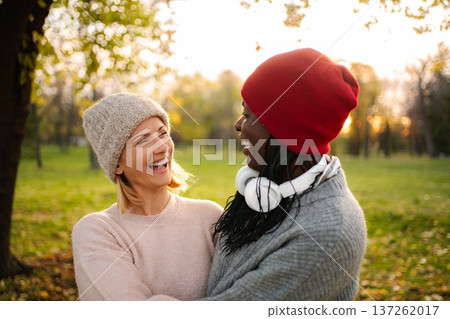 Two women friends laughing in autumn park 137262017