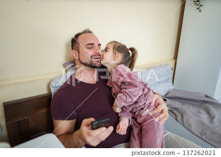 Happy father receiving daughter's kiss using smartphone Happy father receiving daughter's kiss using smartphone 137262021