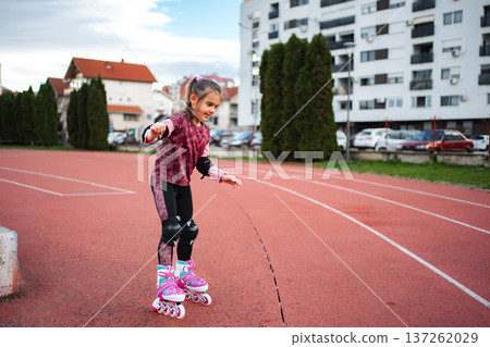 Girl learning rollerblading on outdoor track 137262029