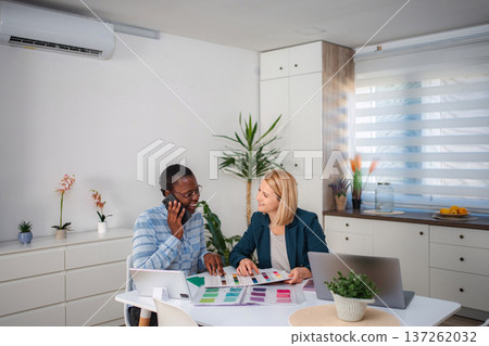 Interior designers discussing color swatches and collaborating on project Interior designers discussing color swatches and collaborating on project 137262032