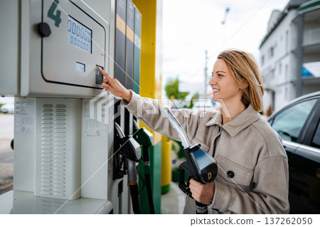 Woman buying gasoline at self-service filling station 137262050