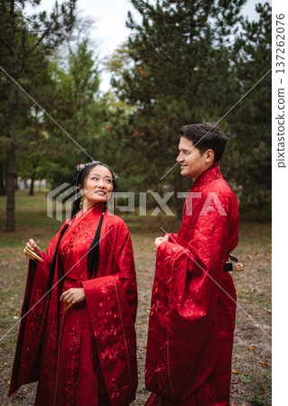 Multicultural couple celebrating traditional Chinese wedding outdoors Multicultural couple celebrating traditional Chinese wedding outdoors 137262076