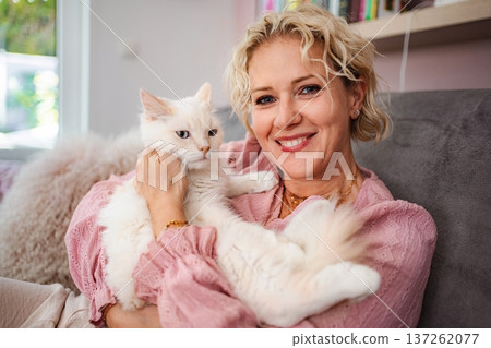 Woman holding fluffy white cat smiling at home 137262077