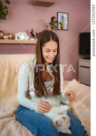 Girl smiling holding fluffy white cat Girl smiling holding fluffy white cat 137262083