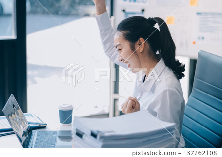 Charming smiling adult woman middle aged woman with curly hair architect designer working on computer in the bright modern office Charming smiling adult woman middle aged woman with curly hair architect designer working on computer in the bright modern office 137262108