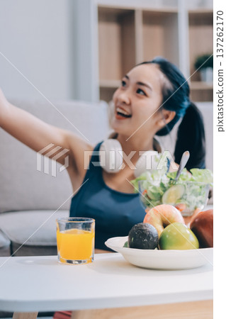Fit young Asian women in activewear sitting on yoga mat and eating fresh vegetable salad after workout, representing clean eating, fitness lifestyle, wellness routine and health balance. Fit young Asian women in activewear sitting on yoga mat and eating fresh vegetable salad after workout, representing clean eating, fitness lifestyle, wellness routine and health balance. 137262170