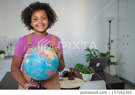 Young girl holding a globe learning about world geography 137262265