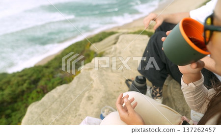 Individuals study map while enjoying ocean breeze and coffee Individuals study map while enjoying ocean breeze and coffee 137262457