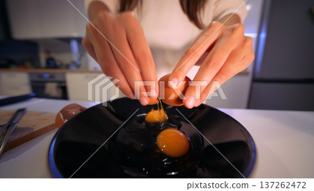 Kitchen scene displaying precise egg and yolk separation technique 137262472
