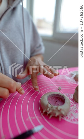 Hands carefully evaluating details of completed clay miniature piece 137262566