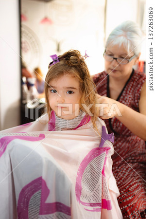 Little girl getting first haircut at hair salon 137263069
