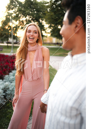 Joyful stroll through the park during golden hour with a friend Joyful stroll through the park during golden hour with a friend 137263160