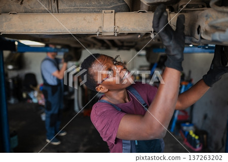 Young african female mechanic repairing car in a workshop 137263202