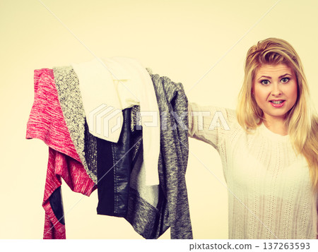 Woman holding many clothing Woman holding many clothing 137263593