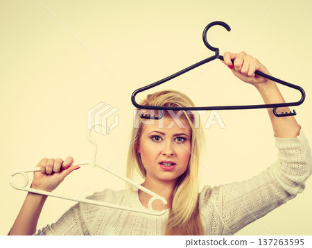 Woman holding clothes hanger Woman holding clothes hanger 137263595