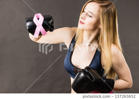 Woman wearing boxing gloves having pink ribbon Woman wearing boxing gloves having pink ribbon 137263652