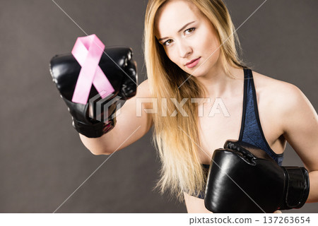 Woman wearing boxing gloves having pink ribbon Woman wearing boxing gloves having pink ribbon 137263654