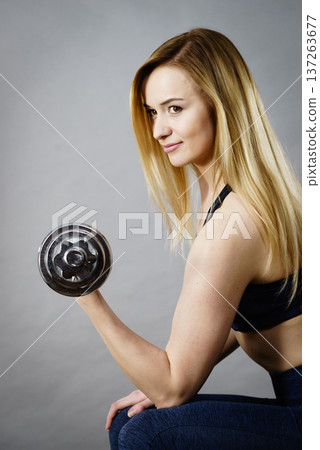 Woman working out at home with dumbbell 137263677