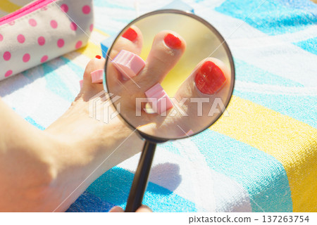 Woman magnifying pedicure Woman magnifying pedicure 137263754