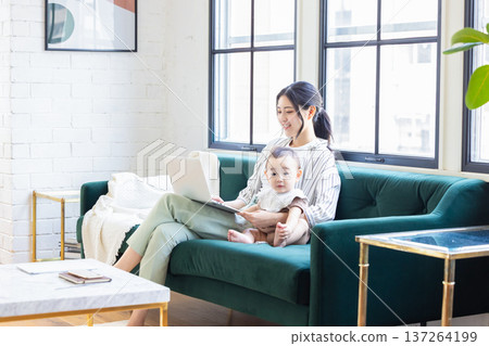 Mother and baby watching personal computer Mother and baby watching personal computer 137264199
