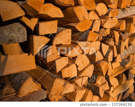 Background Stack of freshly cut firewood in sunlight. Rustic lifestyle and winter preparation in Serbian village. Background Stack of freshly cut firewood in sunlight. Rustic lifestyle and winter preparation in Serbian village. 137264238