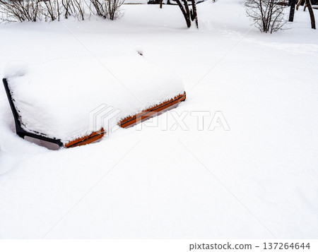 snow-covered bench in snowy city garden snow-covered bench in snowy city garden 137264644