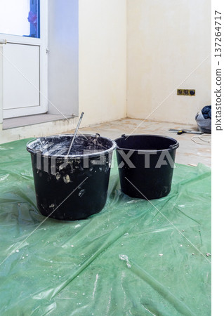 buckets on floor covered with protective film 137264717