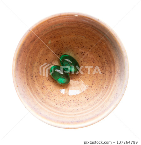 two green pills in ceramic bowl cutout on white two green pills in ceramic bowl cutout on white 137264789