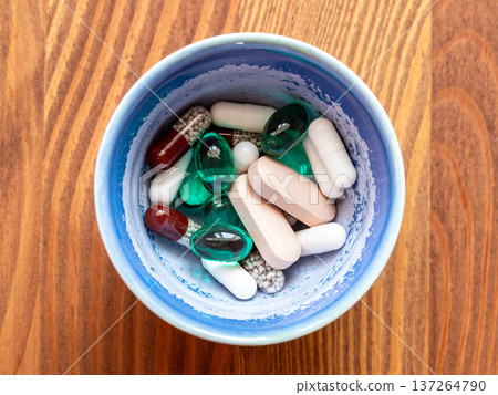 many various pills in ceramic bowl on wooden table many various pills in ceramic bowl on wooden table 137264790
