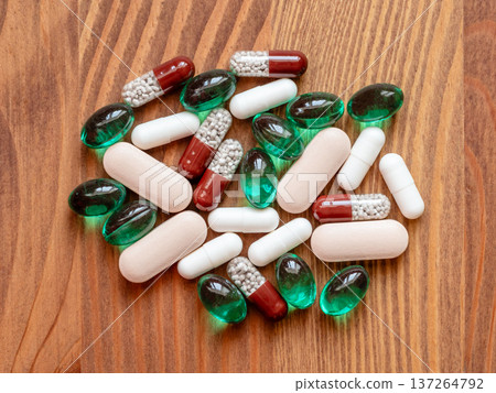 many different pills on wooden table closeup 137264792