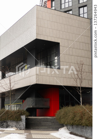 Contemporary architectural building featuring bold red elements against neutral facade, modern urban design concept Contemporary architectural building featuring bold red elements against neutral facade, modern urban design concept 137264943