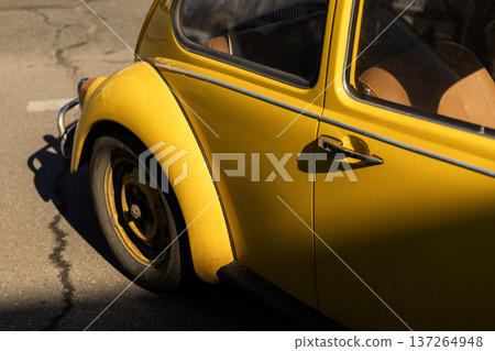 Close up of rear wheel of yellow retro car, classic automotive detail. Close up of rear wheel of yellow retro car, classic automotive detail. 137264948