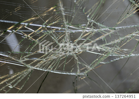 Cracked glass texture forming spiderweb pattern, abstract damage background. Cracked glass texture forming spiderweb pattern, abstract damage background. 137264951