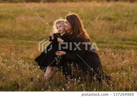 Gentle Mother Guides Young Girl Through Blooming Wildflowers In Bright Meadow Setting Gentle Mother Guides Young Girl Through Blooming Wildflowers In Bright Meadow Setting 137264989