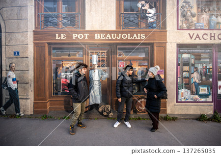 Lyon, france. December 27, 2023. People standing in front of a painted shopfront mural named le pot beaujolais, creating an optical illusion on an urban street 137265035