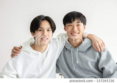 Young people with their arms around each other's shoulders 137265136