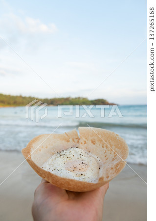 Egg hopper in hand with palm leaf background 137265168