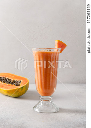 Papaya lassi in glass on gray background. Papaya lassi in glass on gray background. 137265169