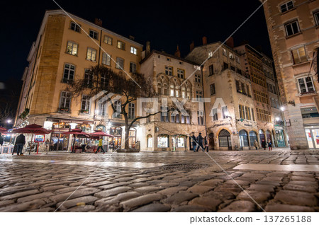 Lyon, france. December 27, 2023. Historic buildings, illuminated facades, and cobblestone square in vieux lyon during the evening. People walking outdoors 137265188