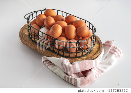 Natural eggs in metal basket against white kitchen background. 137265212