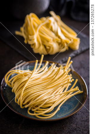 Fresh pasta ready for cooking, showing strands of bigoli set on a black background 137265278