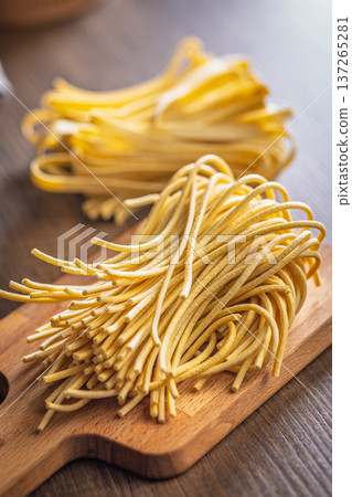 Fresh pasta ready for cooking, showing strands of bigoli set on a wooden background 137265281