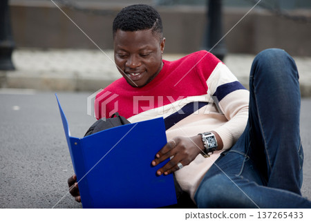 young smiling student studying lying outside young smiling student studying lying outside 137265433