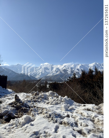 A snow removal site with a view of the Northern Alps from the river flowing through Hakuba A snow removal site with a view of the Northern Alps from the river flowing through Hakuba 137265631