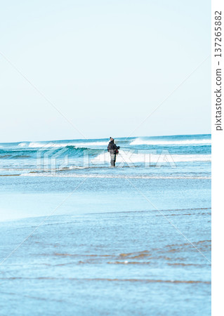 Fisherman standing in the waves 137265882