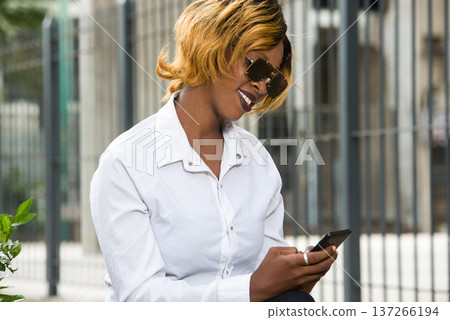 Close-up of young student with mobile phone, smiling. Close-up of young student with mobile phone, smiling. 137266194