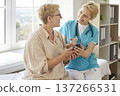 Nurse explaining to happy senior patient how to use health mobile app easy 137266531