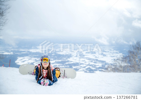 A woman enjoying winter sports on a winter slope A woman enjoying winter sports on a winter slope 137266781